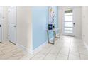 Bright entryway with light tile floors, a console table, and blue accent wall at 601 Drop Shot Dr, Davenport, FL 33896
