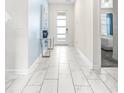 Entryway with a view of the Primary bedroom, light tile floors, and blue accent wall at 601 Drop Shot Dr, Davenport, FL 33896