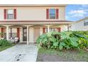 Tan two-story condo with red-trimmed windows and lush landscaping at 980 Canal View Blvd # G1, Port Orange, FL 32129