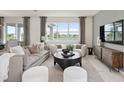 Spacious living room with lake view, comfy seating, and large windows at 289 Woodsage Pl, Lake Alfred, FL 33850
