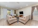 Spacious living room with light beige sofas and a large TV at 501 Lasso Dr, Kissimmee, FL 34747