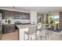 Eat-in kitchen with island seating, stainless steel appliances, and dark cabinetry at 264 Woodsage Pl, Lake Alfred, FL 33850
