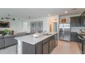 Open concept kitchen with island, stainless steel appliances, and white countertops at 264 Woodsage Pl, Lake Alfred, FL 33850