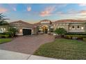 Charming single-story home featuring a tile roof and attached garage with a paved brick driveway and landscaped yard at 7833 Freestyle Ln, Winter Garden, FL 34787
