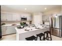 Modern kitchen with gray cabinets, stainless steel appliances, and an island at 1416 Derry Ave, Haines City, FL 33844