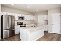 Modern kitchen featuring white cabinets, stainless steel appliances, and an island at 4022 Gardenia Ave, Lake Hamilton, FL 33851