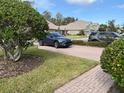 Brick driveway with landscaping and a parked car at 6528 Sedgeford Dr, Lakeland, FL 33811