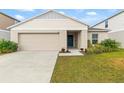 Tan house with a two-car garage and landscaped lawn at 1536 Axel Cir, Winter Haven, FL 33880