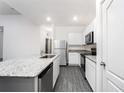 Kitchen features white cabinets, granite countertops, and stainless steel appliances at 308 Bass Ct, Poinciana, FL 34759