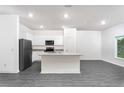 Bright kitchen features white cabinets, gray granite countertops, and stainless steel appliances at 308 Bass Ct, Poinciana, FL 34759