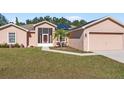 Tan house with solar panels, screened porch, and two-car garage at 3189 Winchester Estates Loop, Lakeland, FL 33810
