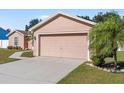 Two-car garage with light tan door and driveway at 3189 Winchester Estates Loop, Lakeland, FL 33810