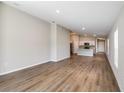 Spacious living room showcasing wood-look floors and an open layout to the kitchen at 6244 Sw 96Th Pl, Ocala, FL 34476