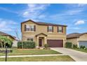 Two-story house with brown accents and a landscaped lawn at 8710 Hinsdale Heights Dr, Polk City, FL 33868