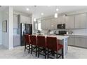 Modern kitchen featuring gray cabinets, a large island, and stainless steel appliances at 4815 Waltham Forest Dr, Davenport, FL 33837