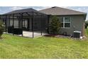 Screened patio with grilling area and spacious grassy lawn at 5450 Sunshine Dr, Wildwood, FL 34785