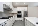 Modern kitchen featuring white cabinets, stainless steel appliances, and quartz countertops at 7748 Somersworth Dr, Kissimmee, FL 34747
