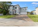 Two-story house with gray siding, brick driveway and landscaped lawn at 213 Aidans Ldg, Haines City, FL 33844