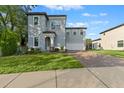 Two-story house with gray siding, brick driveway, and green lawn at 213 Aidans Ldg, Haines City, FL 33844