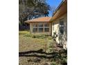 Tan house back with a sunroom and landscaped yard at 3637 Dale St, Lakeland, FL 33812