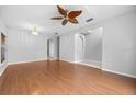 Bright living room with hardwood floors, a ceiling fan, and large windows at 10555 Leader Ln, Orlando, FL 32825
