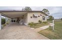 Mobile home with carport, landscaping, and paved driveway at 6055 Grand Oaks Se Dr, Winter Haven, FL 33884