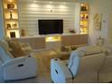 Living room with built-in shelving and a large TV at 621 San Augusto Dr, Poinciana, FL 34759