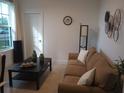 Comfortable living room with neutral décor, a cozy sofa, and natural light from the window at 621 San Augusto Dr, Poinciana, FL 34759
