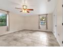 Bright bedroom with tile floors, ceiling fan, and large windows at 1528 Walker Rd, Lakeland, FL 33810