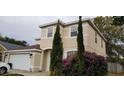 Two-story house with beige exterior, attached garage, and landscaping at 2938 Egrets Landing Dr, Lake Mary, FL 32746