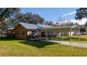 Inviting single-story house with an attached carport and fresh landscaping at 1507 Hontoon Rd, Deland, FL 32720