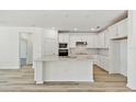 Bright kitchen featuring white cabinetry, stainless steel appliances, and spacious center island at 1254 Lakeridge Way, Lake Alfred, FL 33850