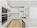 Bright open kitchen featuring white cabinetry, stainless steel appliances, and center island at 1254 Lakeridge Way, Lake Alfred, FL 33850