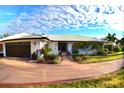 Single-story home with a metal roof, well-maintained landscaping, and a circular driveway at 225 Temple Cir, Eustis, FL 32726