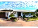 Front view of a single-story home with walkway and manicured landscaping at 225 Temple Cir, Eustis, FL 32726