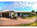 House exterior showcasing a metal roof, well-maintained landscaping, and a curved driveway at 225 Temple Cir, Eustis, FL 32726