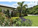 Lush front yard landscaping with vibrant flowers, shrubs, and green grass create a serene outdoor setting at 225 Temple Cir, Eustis, FL 32726