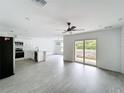 Open-concept living space featuring tile floors, modern ceiling fan, and sliding glass doors leading to the backyard at 2449 Jungle St, Lakeland, FL 33801