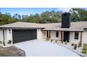 Modern home exterior with a black garage door and well-manicured landscaping at 817 Helen Ave, Deland, FL 32720