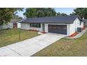 Newly renovated home with a gray garage door and landscaping at 156 Whitman Rd, Winter Haven, FL 33884