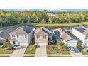 Two-story home with well-maintained landscaping, pond view, and a two-car garage in a Gathering neighborhood at 163 Tiny Flower Rd, Davenport, FL 33837