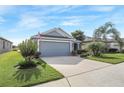 House exterior with gray siding, two-car garage, and well-manicured lawn at 3782 Hampton Hills Dr, Lakeland, FL 33810