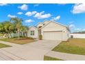 Tan one-story house with a two-car garage and palm tree at 1066 Krenson Woods Rd, Lakeland, FL 33813