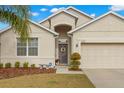 Tan one-story house with a two-car garage and palm tree at 1066 Krenson Woods Rd, Lakeland, FL 33813