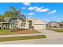 Tan one-story house with a two-car garage and palm tree at 1066 Krenson Woods Rd, Lakeland, FL 33813