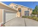 A two-car garage and front entrance of a charming home are nicely landscaped at 108 Emeraldview Ave, Davenport, FL 33897