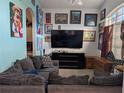 Bright living room with large TV, comfy couches, and wall art at 108 Emeraldview Ave, Davenport, FL 33897