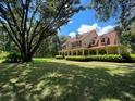 Two-story house with wrap-around porch, and mature trees at 4200 Joslyn Ln, Lady Lake, FL 32159