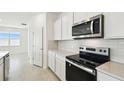 Stainless steel appliances, white cabinetry, and bright natural light in the kitchen at 1258 Lakeridge Way, Lake Alfred, FL 33850