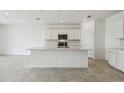 Bright, open kitchen featuring an island, stainless steel appliances, and white cabinetry at 1622 Ruby Ln, Lake Alfred, FL 33850